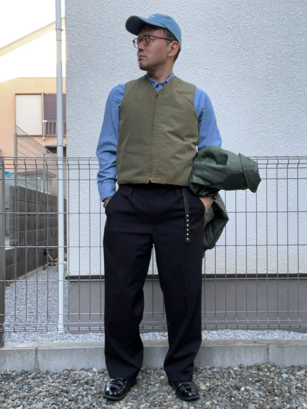 ベージュ系のベスト、ブルー系のシャツ/ブラウス、ブラック系のスラックスを着用したメンズの冬コーディネートの3枚目の写真