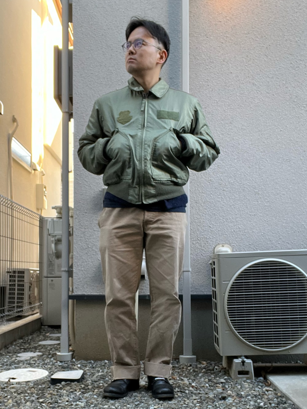 グリーン系のミリタリージャケット、ブルー系のTシャツ/カットソー、ブルー系のカーディガン/ボレロを着用したメンズの冬コーディネートの2枚目の写真