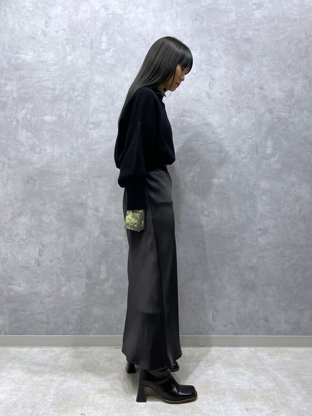 ブラック系のニット/セーター、ブラック系のスカート、グリーン系のシャツ/ブラウスを着用したレディースの秋コーディネートの3枚目の写真