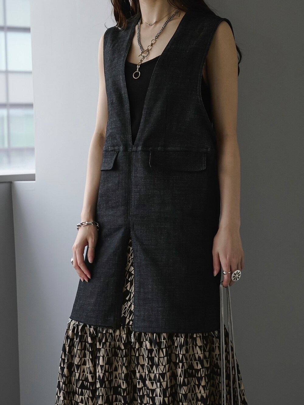 ブラック系のベスト、ブラック系のスカートを着用したレディースの夏コーディネートの3枚目の写真