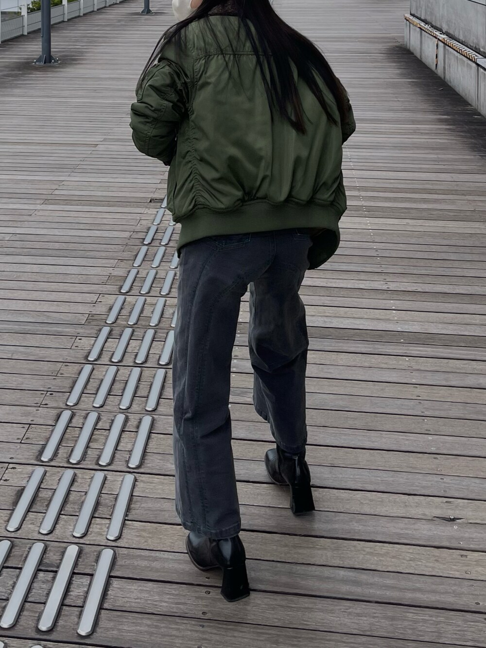 パープル系のニット/セーター、グレー系のパンツを着用したレディースの秋コーディネートの3枚目の写真