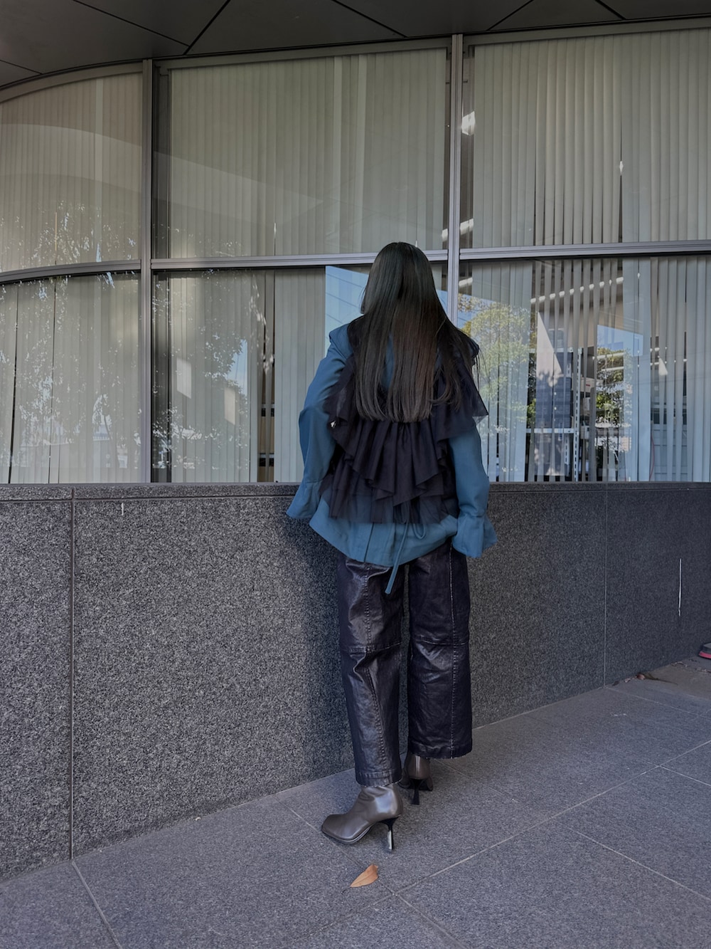 ブラック系のパンツ、ブラック系のベスト、グリーン系のテーラードジャケットを着用したレディースの秋コーディネートの3枚目の写真