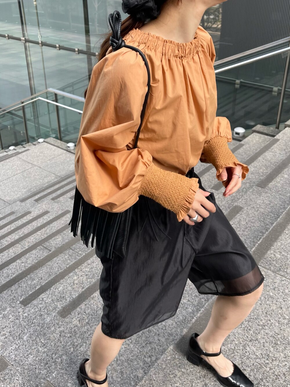 ブラック系のその他パンツ、オレンジ系のシャツ/ブラウス、ブラック系のパンプスを着用したレディースの春コーディネートの3枚目の写真