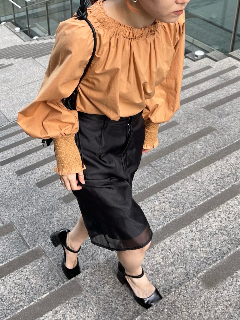 ブラック系のその他パンツ、オレンジ系のシャツ/ブラウス、ブラック系のパンプスを着用したレディースの春コーディネートの2枚目の写真