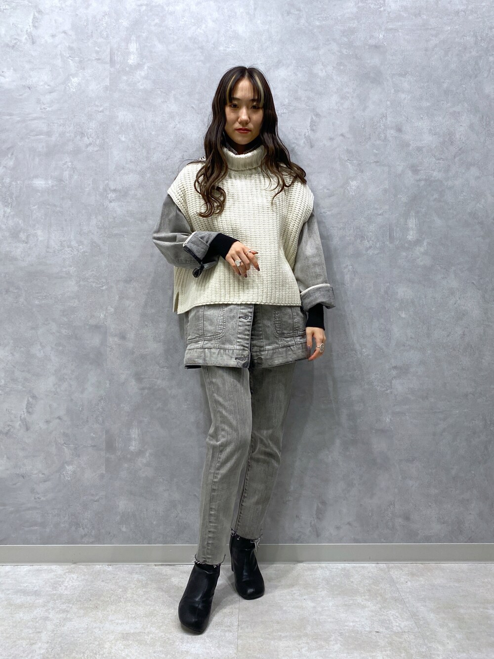 グレー系のデニムパンツ、グレー系のデニムジャケット、ホワイト系のニット/セーターを着用したレディースの秋コーディネートの2枚目の写真