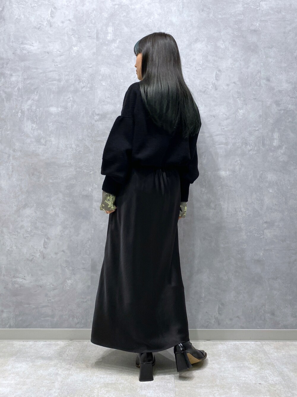 ブラック系のニット/セーター、ブラック系のスカート、グリーン系のシャツ/ブラウスを着用したレディースの秋コーディネートの4枚目の写真