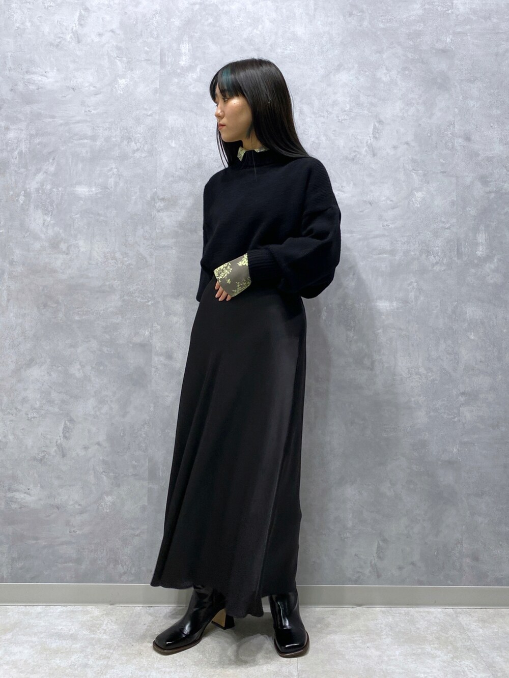 ブラック系のニット/セーター、ブラック系のスカート、グリーン系のシャツ/ブラウスを着用したレディースの秋コーディネートの5枚目の写真