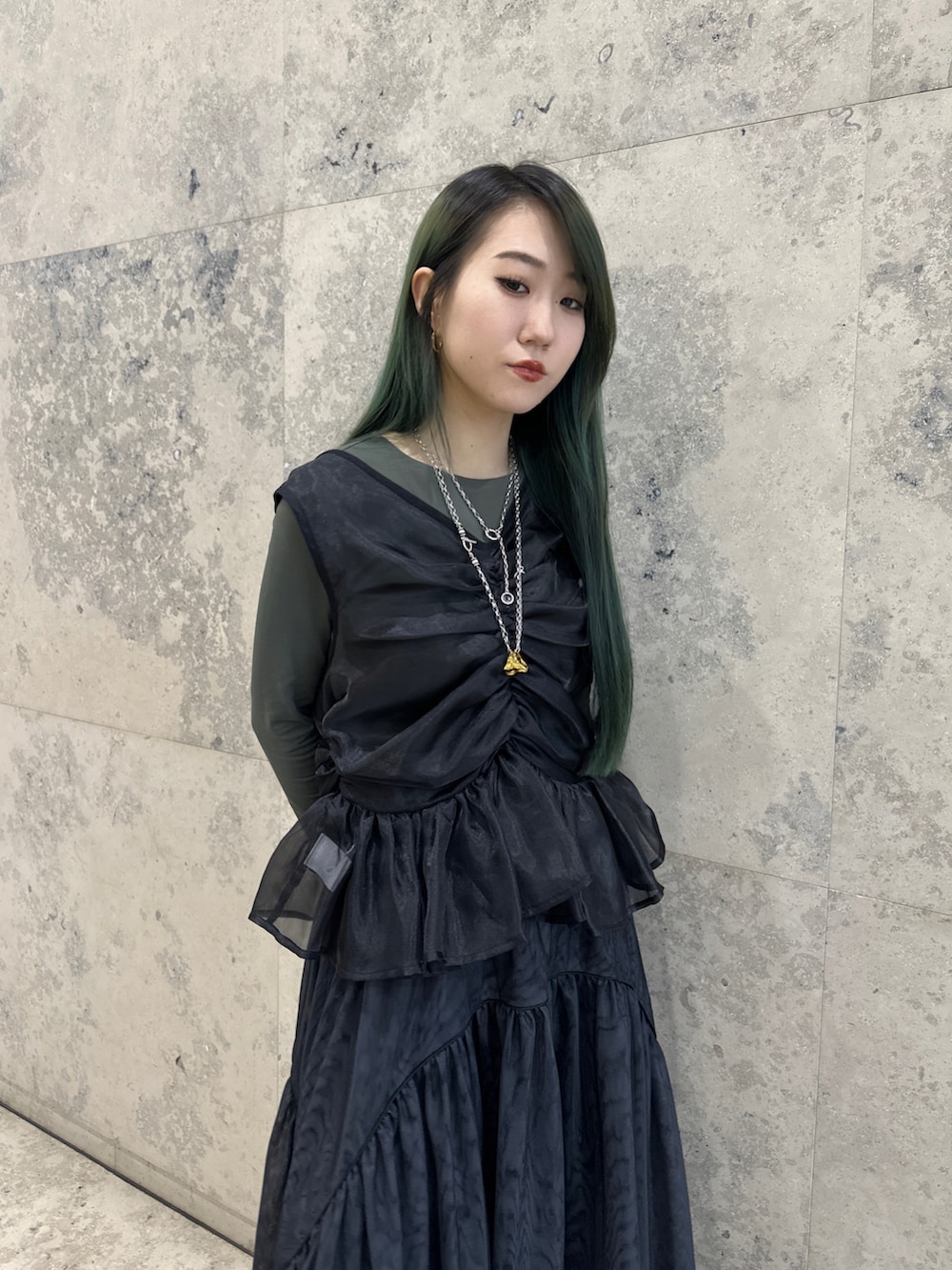 ブラック系のベスト、ブラック系のスカートを着用したレディースの春コーディネートの2枚目の写真