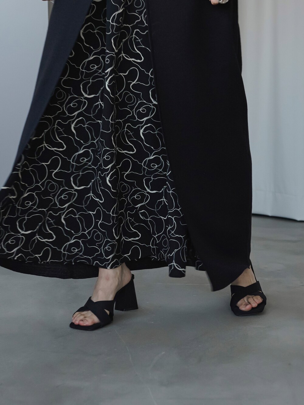 ブラック系のニット/セーター、ブラック系のワンピースを着用したレディースの夏コーディネートの2枚目の写真