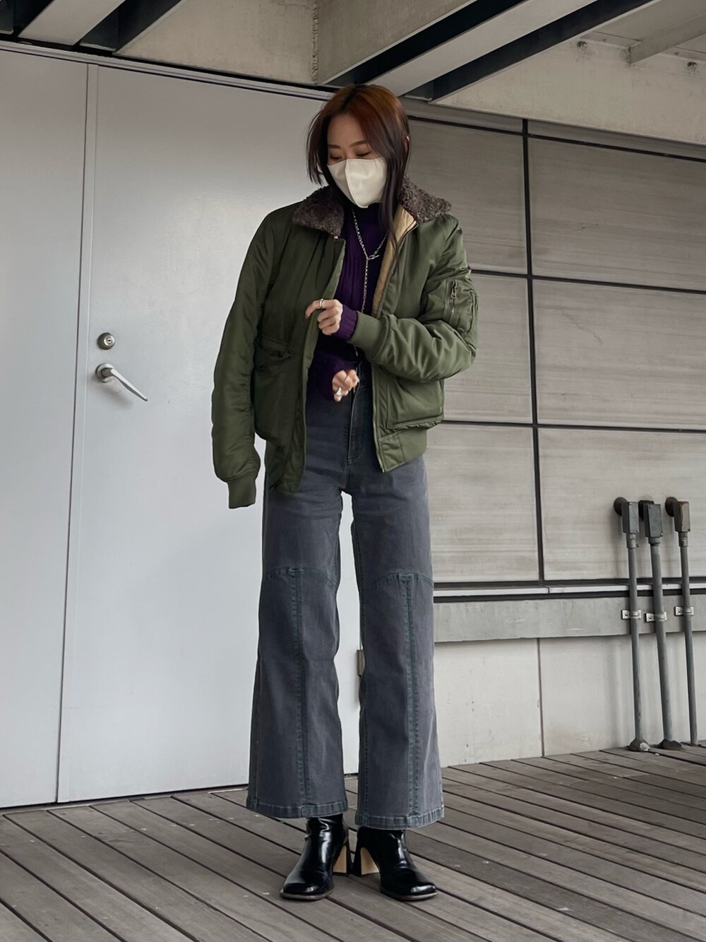 パープル系のニット/セーター、グレー系のパンツを着用したレディースの秋コーディネートの2枚目の写真