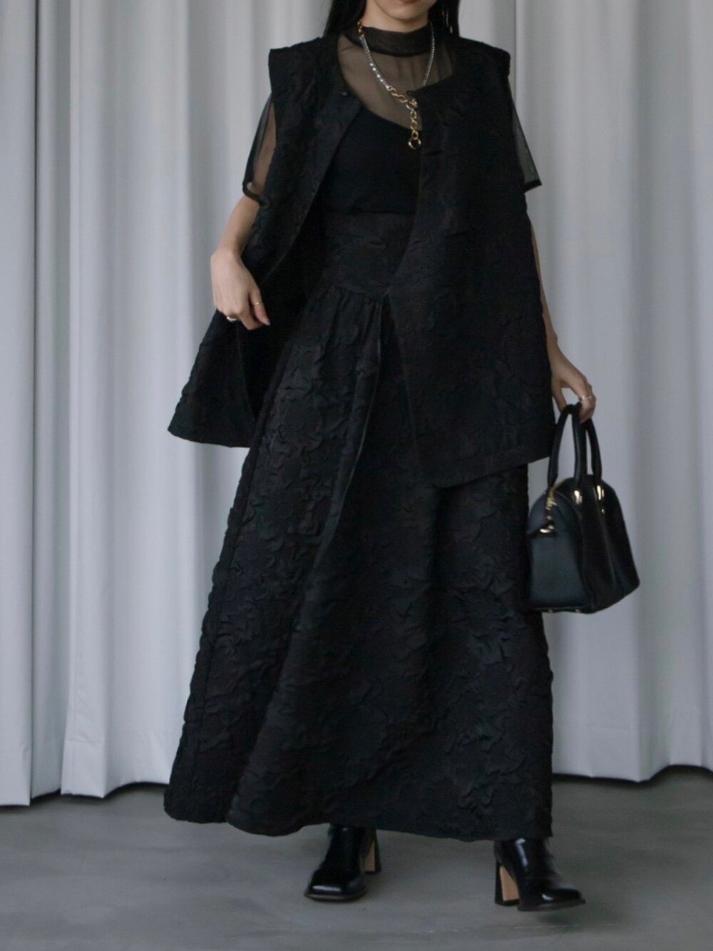 ブラック系のベスト、ブラック系のスカート、ブラック系のTシャツ/カットソーを着用したレディースの秋コーディネートの3枚目の写真