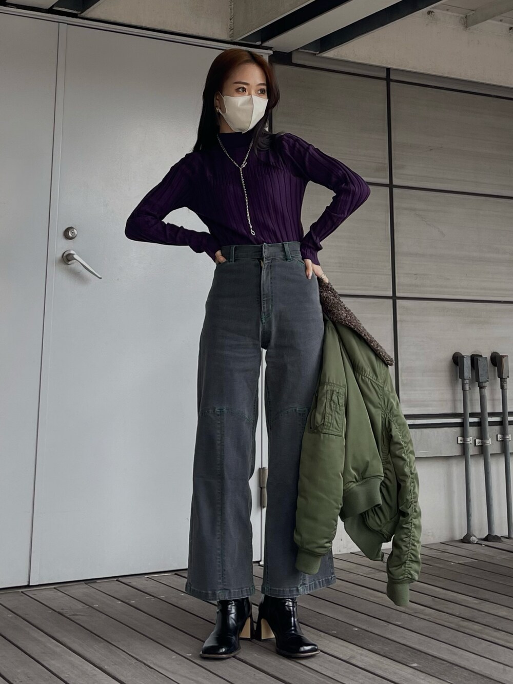 パープル系のニット/セーター、グレー系のパンツを着用したレディースの秋コーディネートの4枚目の写真