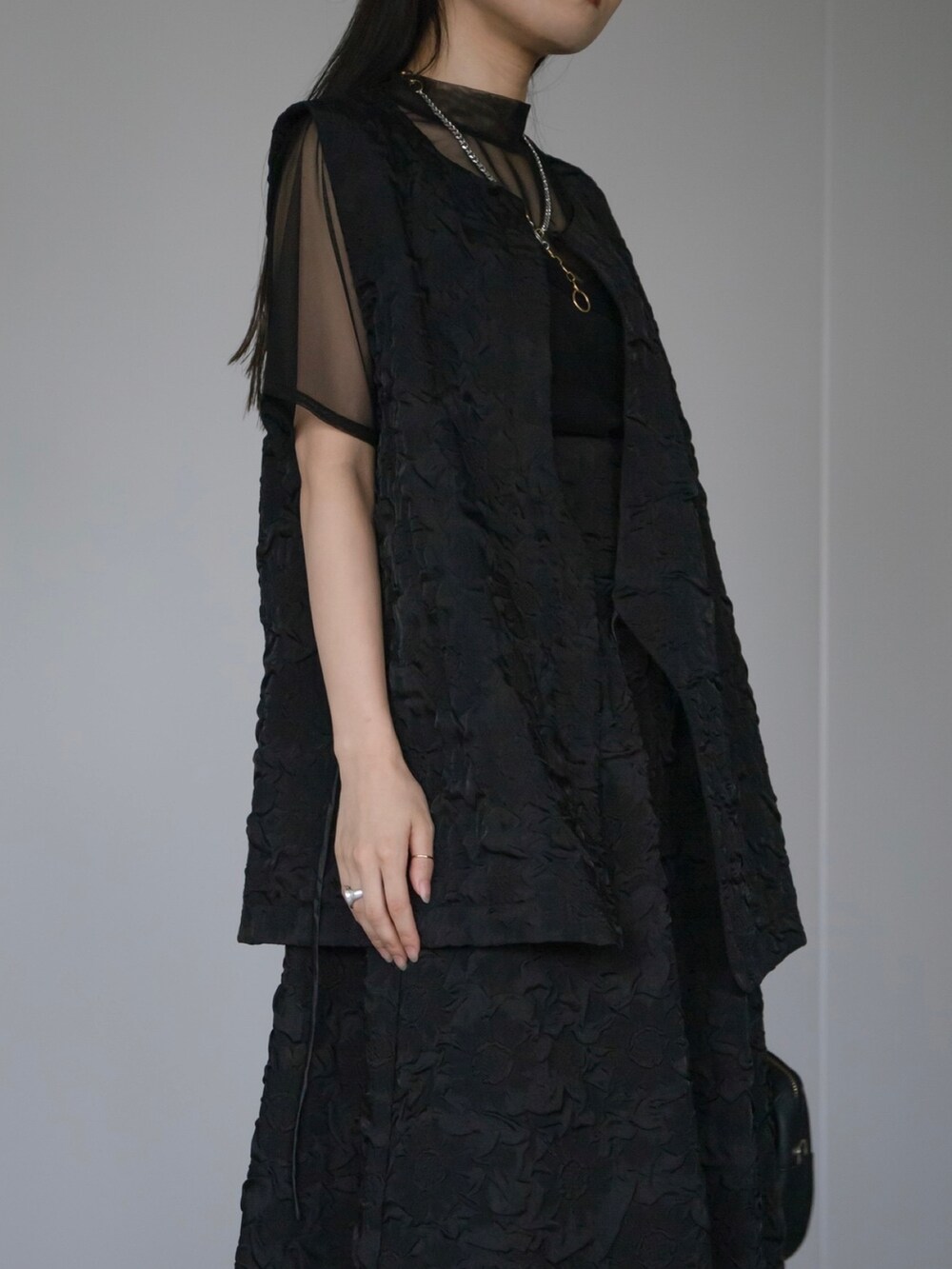 ブラック系のベスト、ブラック系のスカート、ブラック系のTシャツ/カットソーを着用したレディースの秋コーディネートの2枚目の写真