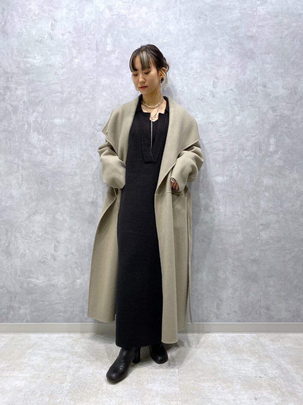 グリーン系のジャケット/アウター、ブラック系のワンピース、ブラック系のシューズを着用したレディースの秋コーディネートの2枚目の写真