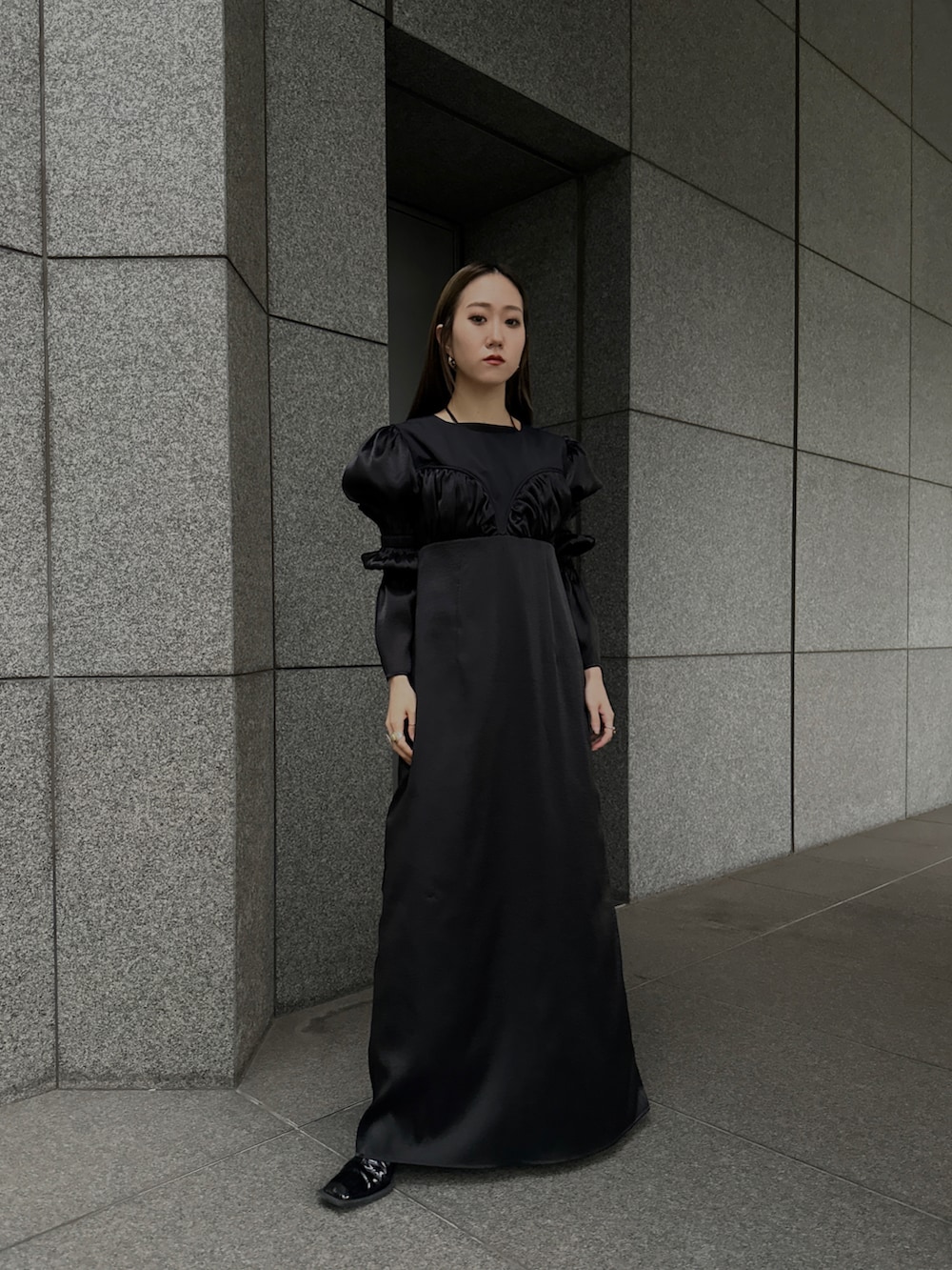 ブラック系のドレスを着用したレディースの春コーディネートの3枚目の写真