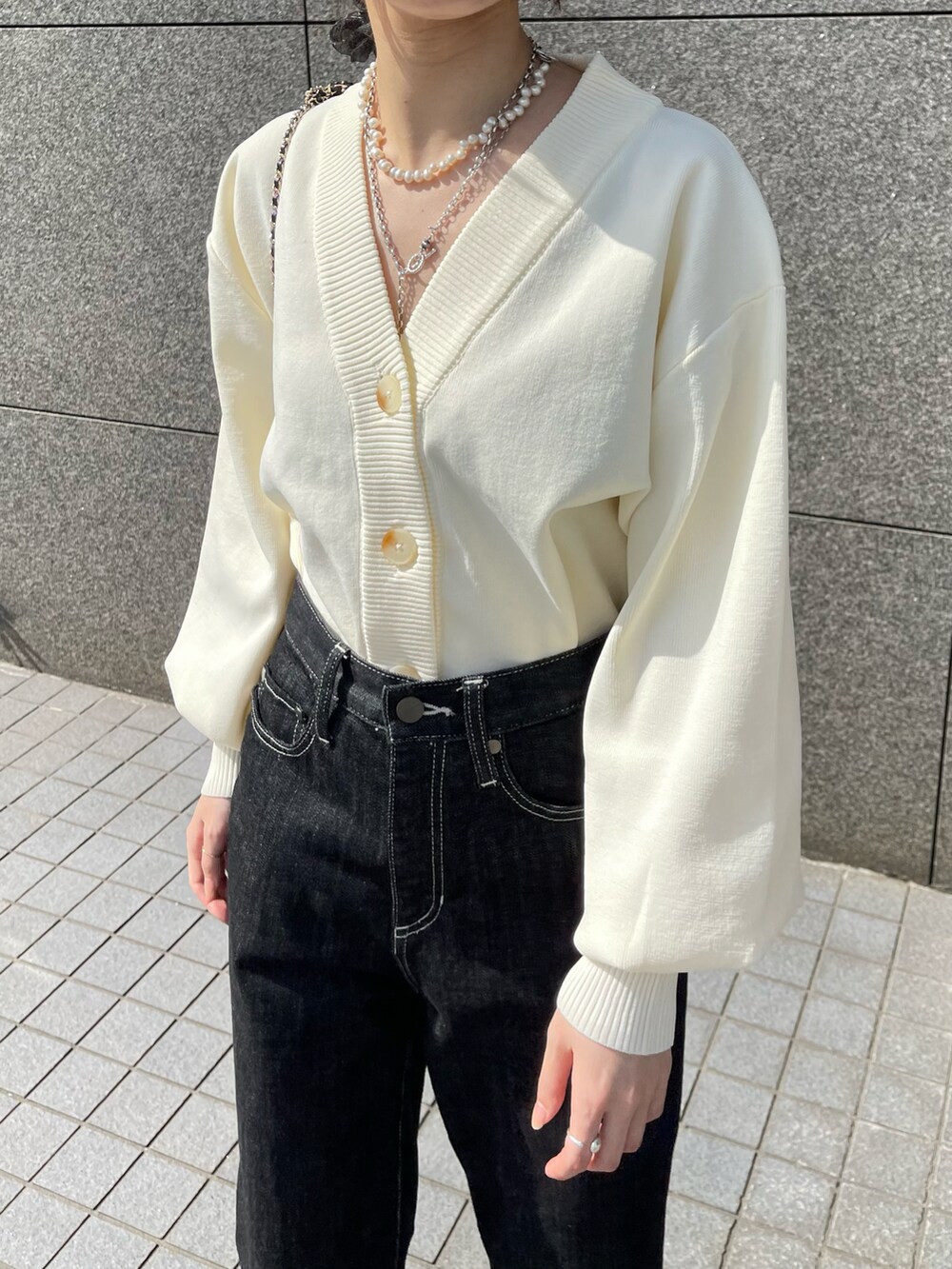 ホワイト系のカーディガン/ボレロ、ブラック系のデニムパンツ、ブラック系のブーツを着用したレディースの春コーディネートの3枚目の写真