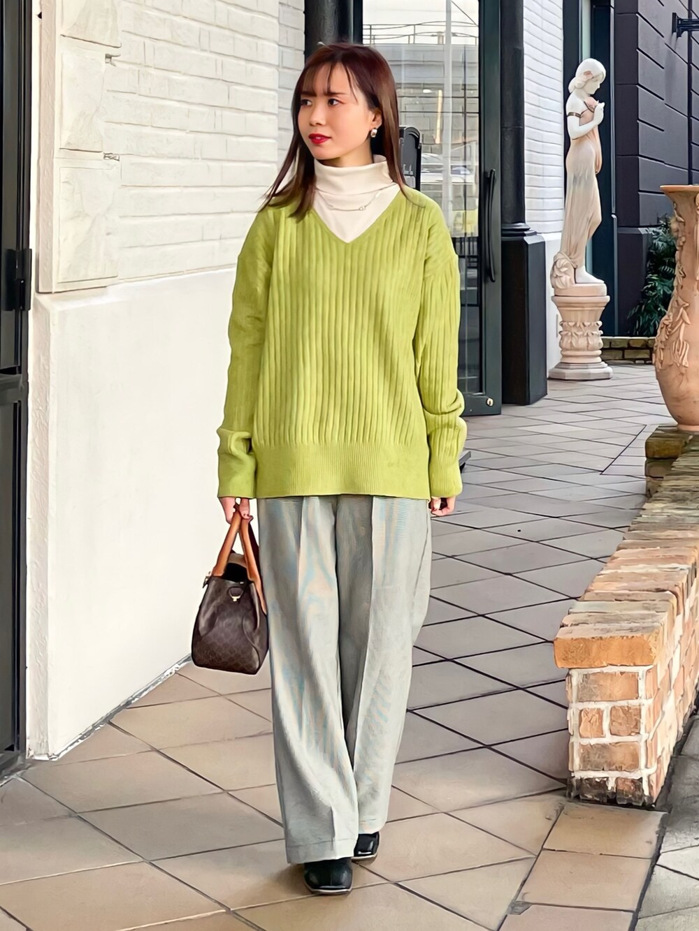 ブラック系のその他アウター、グリーン系のニット/セーター、ホワイト系のTシャツ/カットソーを着用したレディースの冬コーディネートの5枚目の写真