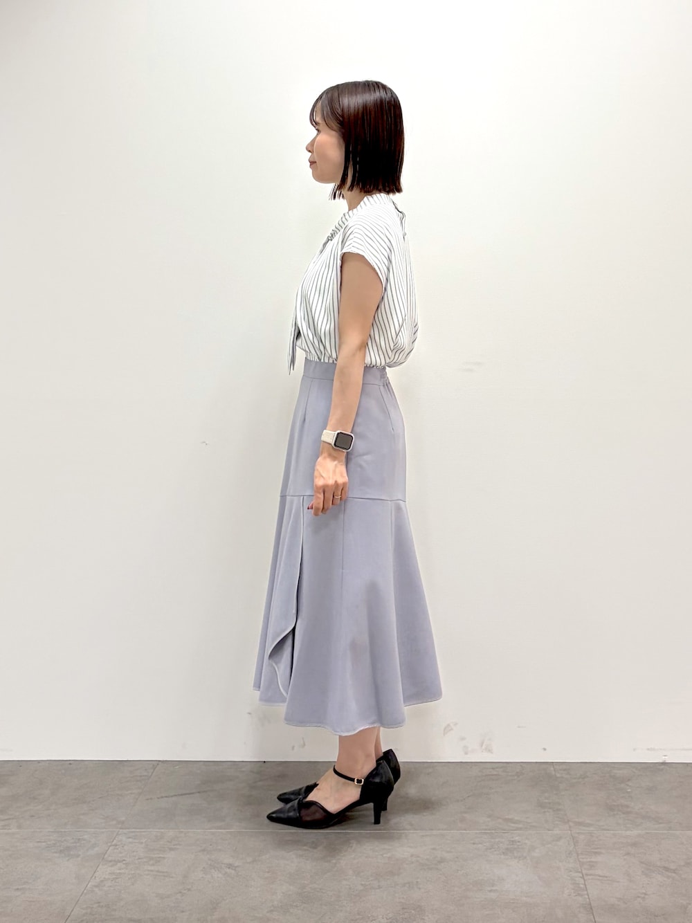 ホワイト系のカーディガン/ボレロ、ベージュ系のシャツ/ブラウス、グレー系のスカートを着用したレディースの夏コーディネートの8枚目の写真