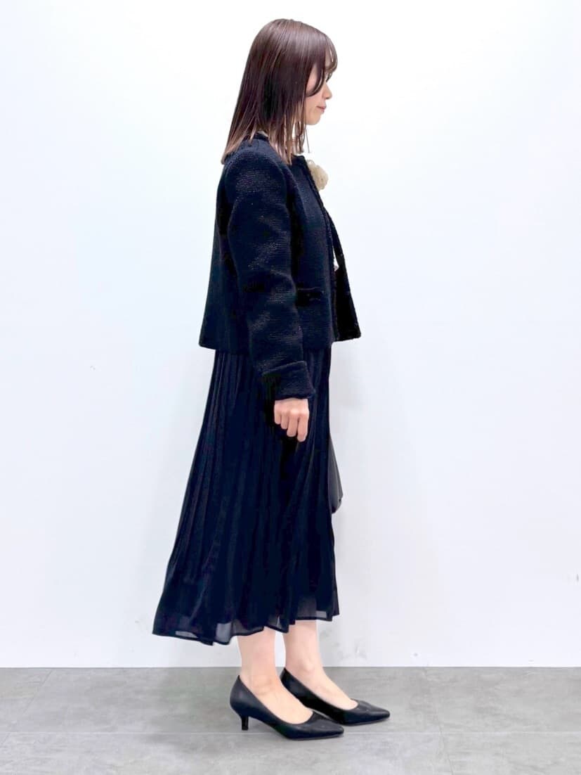 ブルー系のノーカラージャケット、ベージュ系のシャツ/ブラウス、ブルー系のスカートを着用したレディースの春コーディネートの4枚目の写真