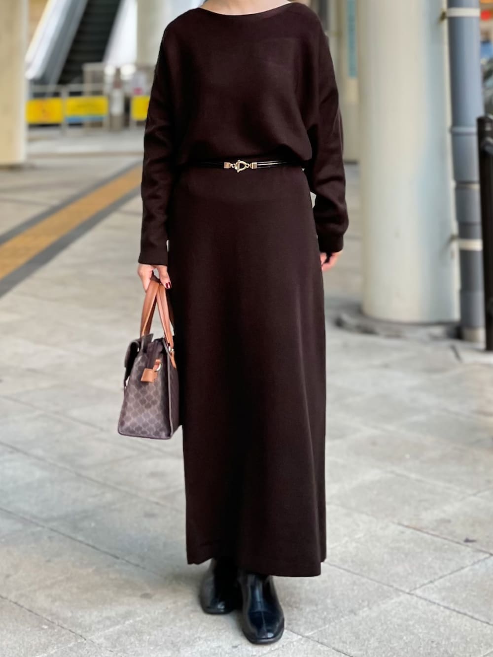 ベージュ系のチェスターコート、ブラウン系のニット/セーター、ブラウン系のスカートを着用したレディースの冬コーディネートの4枚目の写真