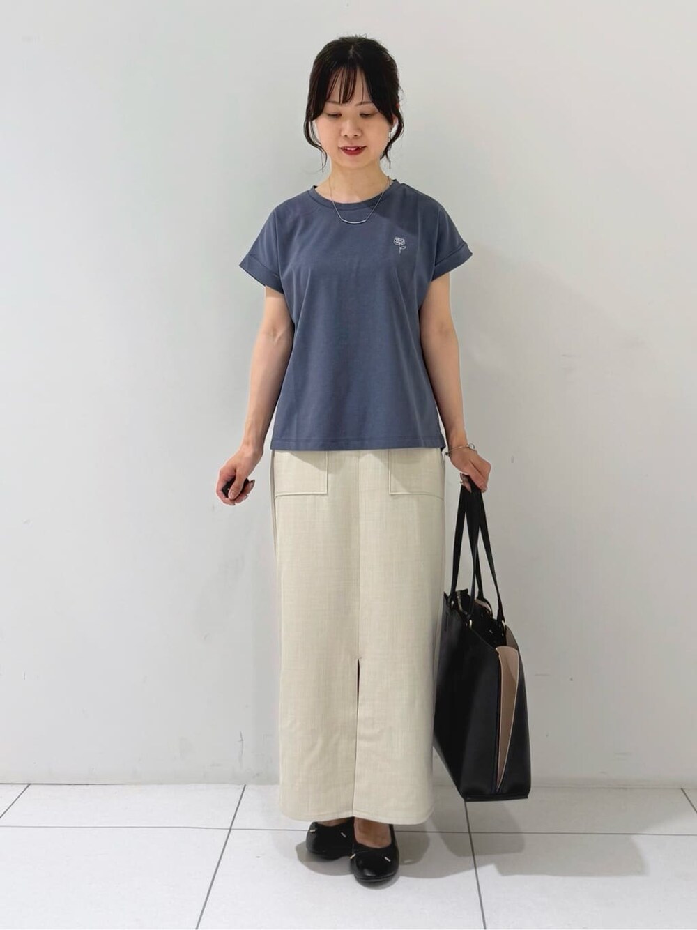 ブラック系のカーディガン/ボレロ、グレー系のTシャツ/カットソー、ベージュ系のスカートを着用したレディースの夏コーディネートの8枚目の写真