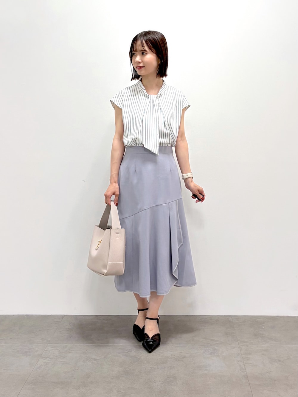ホワイト系のカーディガン/ボレロ、ベージュ系のシャツ/ブラウス、グレー系のスカートを着用したレディースの夏コーディネートの7枚目の写真
