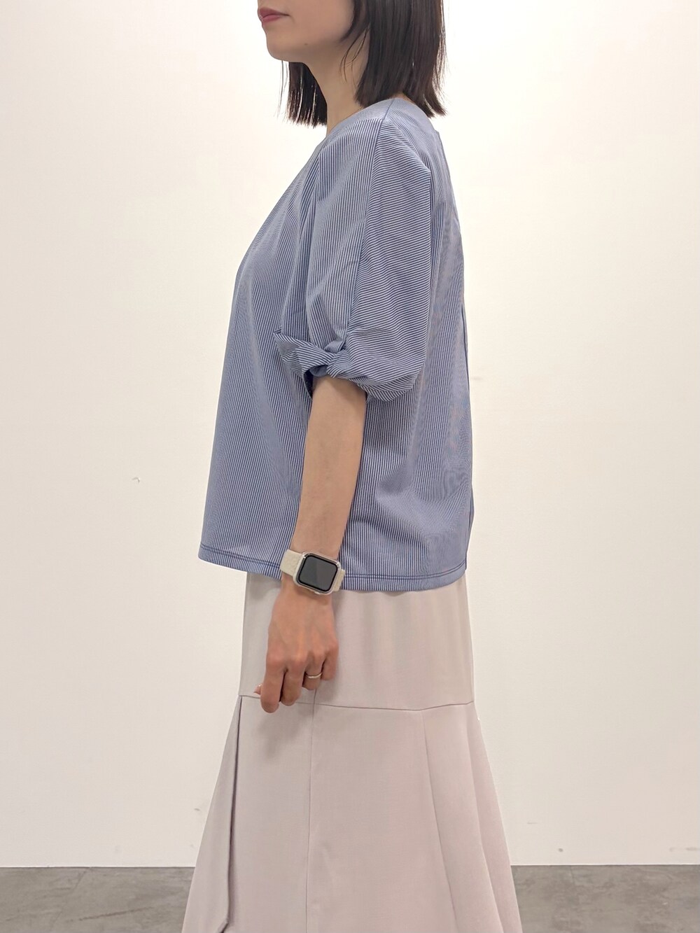 ブルー系のTシャツ/カットソー、ベージュ系のスカート、ホワイト系のトートバッグを着用したレディースの春コーディネートの9枚目の写真