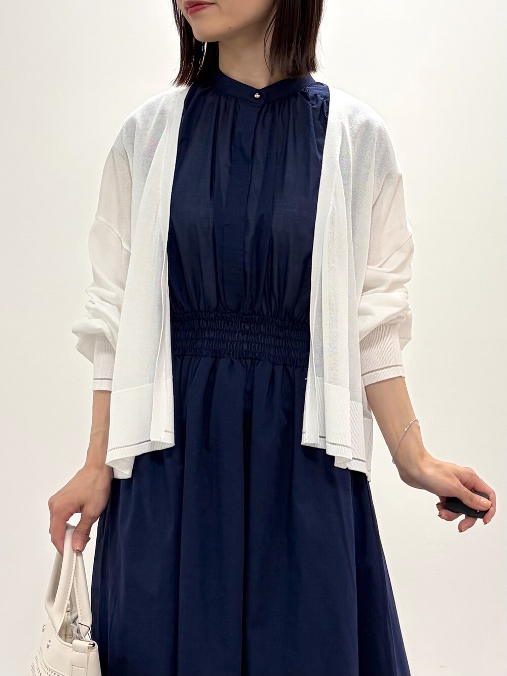 ブルー系のワンピース、ホワイト系のトートバッグ、ベージュ系のパンプスを着用したレディースの春コーディネートの4枚目の写真