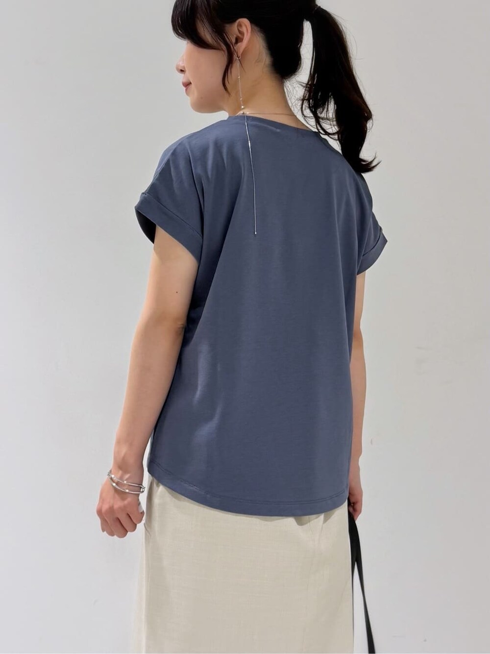 ブラック系のカーディガン/ボレロ、グレー系のTシャツ/カットソー、ベージュ系のスカートを着用したレディースの夏コーディネートの4枚目の写真