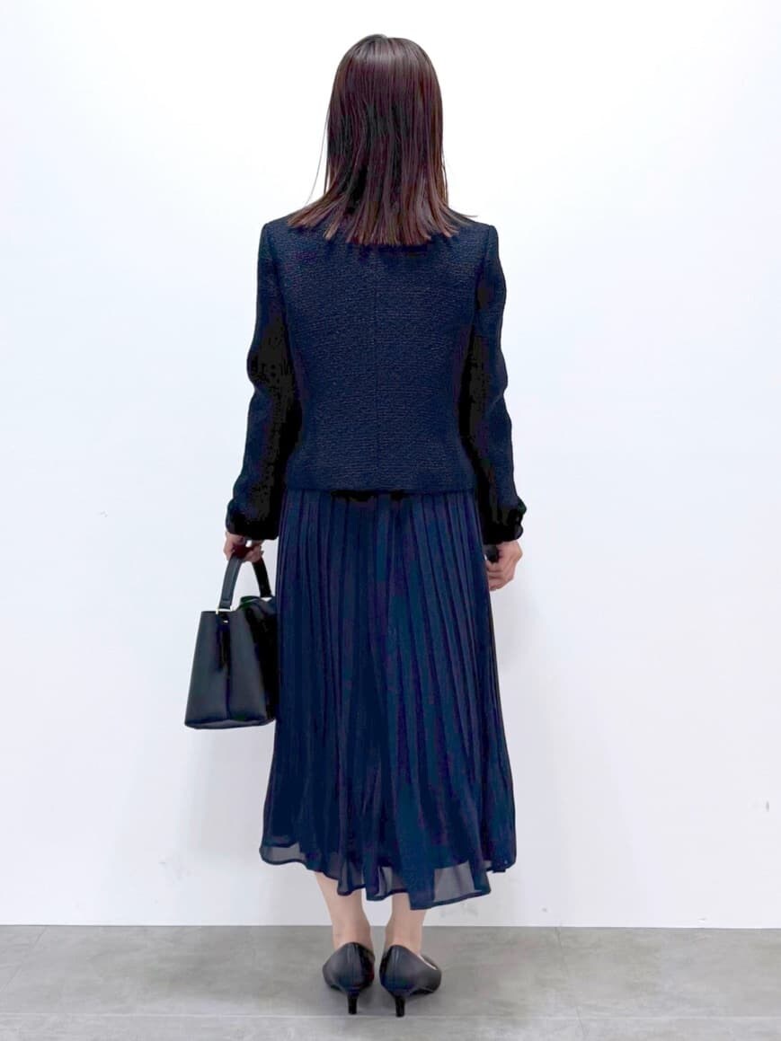 ブルー系のノーカラージャケット、ベージュ系のシャツ/ブラウス、ブルー系のスカートを着用したレディースの春コーディネートの3枚目の写真