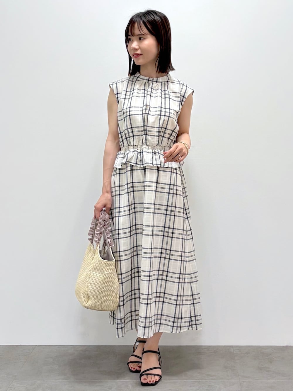 ホワイト系のカーディガン/ボレロ、ベージュ系のワンピース、ベージュ系のトートバッグを着用したレディースの春コーディネートの2枚目の写真