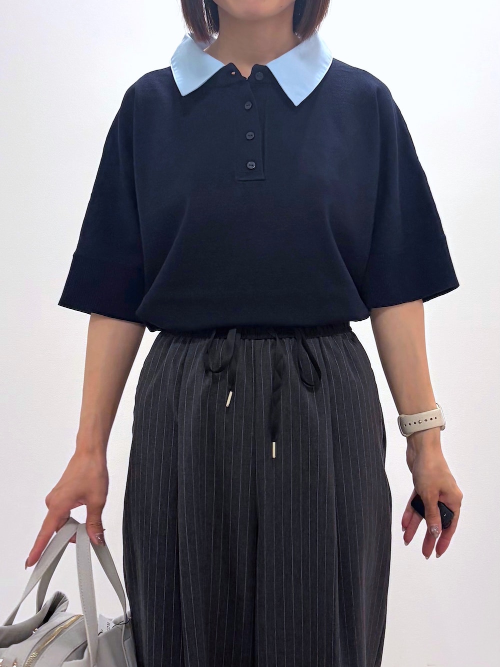 ブルー系のニット/セーター、グレー系のその他パンツ、ベージュ系のボストンバッグを着用したレディースの秋コーディネートの2枚目の写真