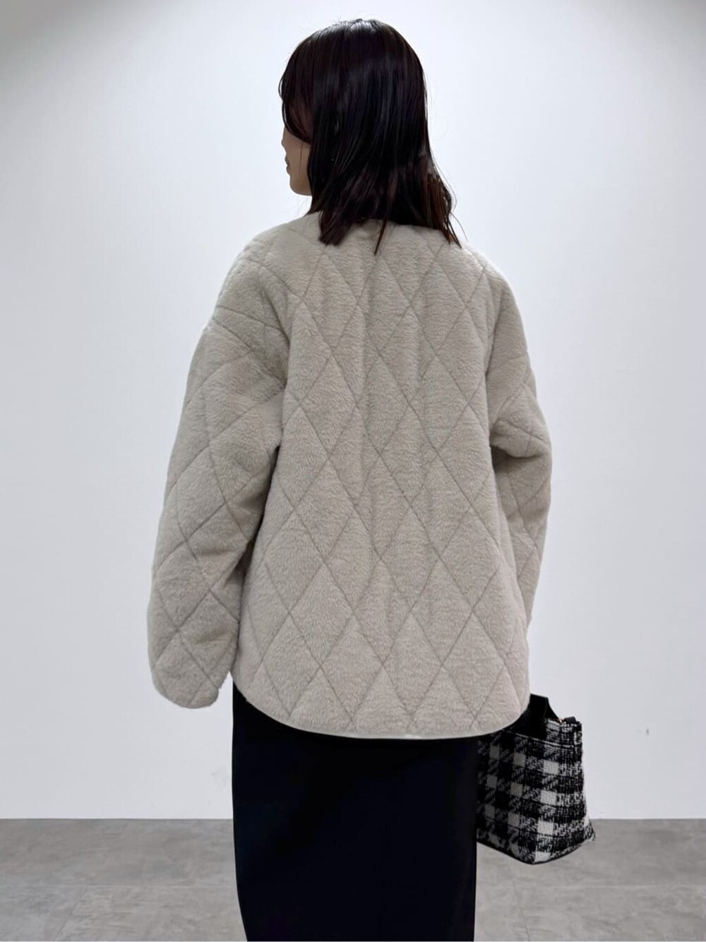 ブラック系のワンピース、ホワイト系のシャツ/ブラウス、ブラック系のハンドバッグを着用したレディースの冬コーディネートの5枚目の写真