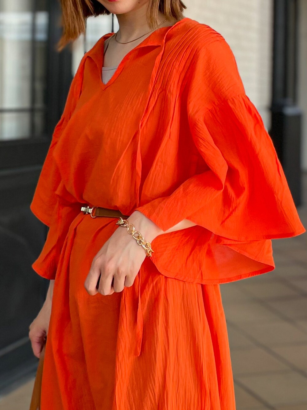 オレンジ系のワンピース、イエロー系のトートバッグを着用したレディースの夏コーディネートの3枚目の写真