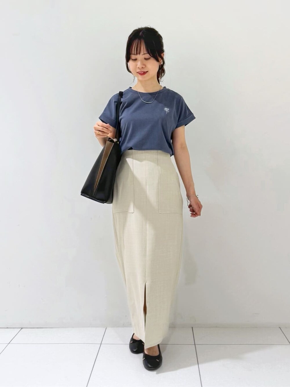ブラック系のカーディガン/ボレロ、グレー系のTシャツ/カットソー、ベージュ系のスカートを着用したレディースの夏コーディネートの2枚目の写真