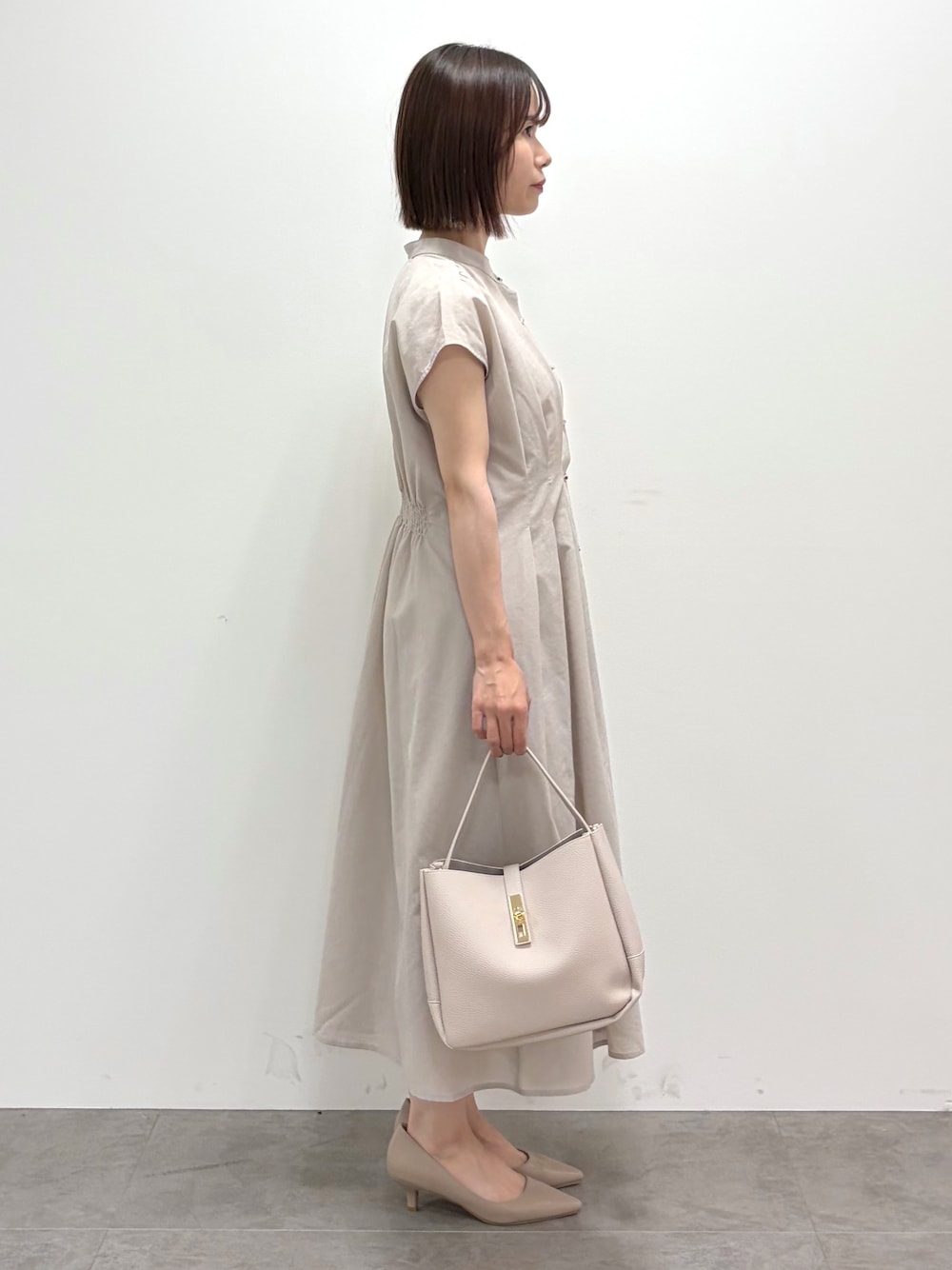 グレー系のトートバッグ、ベージュ系のパンプスを着用したレディースの夏コーディネートの3枚目の写真