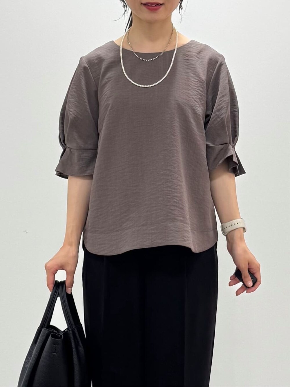 ブラウン系のシャツ/ブラウス、ブラック系のその他パンツ、ブラック系のパンプスを着用したレディースの夏コーディネートの3枚目の写真
