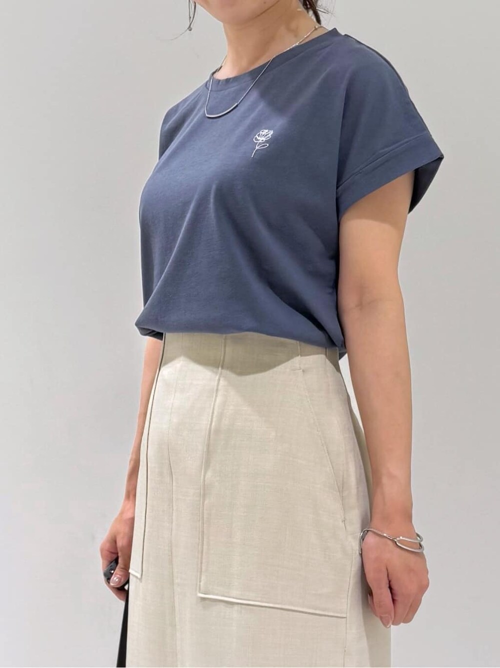 ブラック系のカーディガン/ボレロ、グレー系のTシャツ/カットソー、ベージュ系のスカートを着用したレディースの夏コーディネートの3枚目の写真