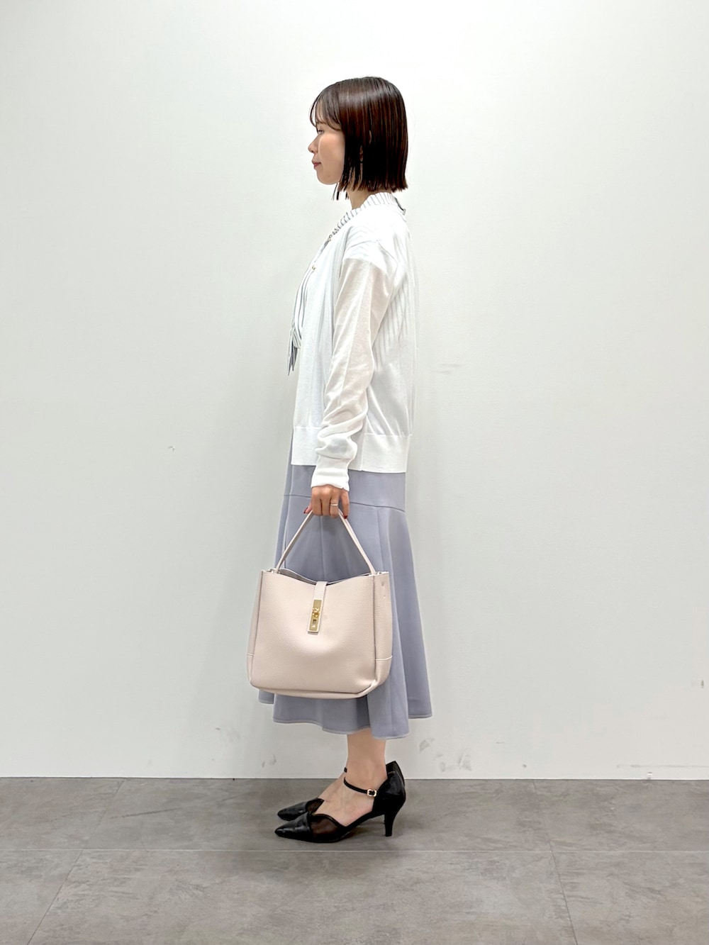 ホワイト系のカーディガン/ボレロ、ベージュ系のシャツ/ブラウス、グレー系のスカートを着用したレディースの夏コーディネートの4枚目の写真