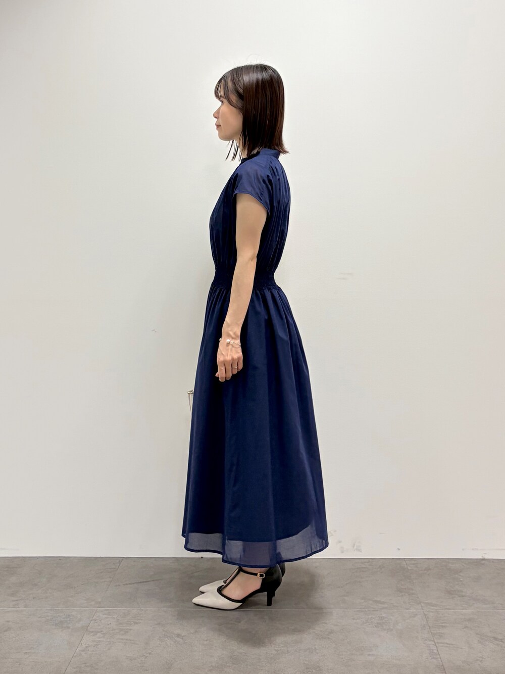 ブルー系のワンピース、ホワイト系のトートバッグ、ベージュ系のパンプスを着用したレディースの春コーディネートの5枚目の写真