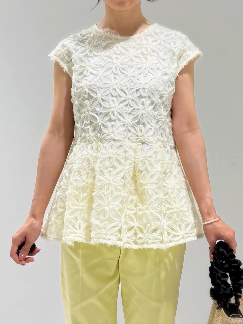 ホワイト系のシャツ/ブラウス、イエロー系のその他パンツ、ブラック系のトートバッグを着用したレディースの春コーディネートの4枚目の写真