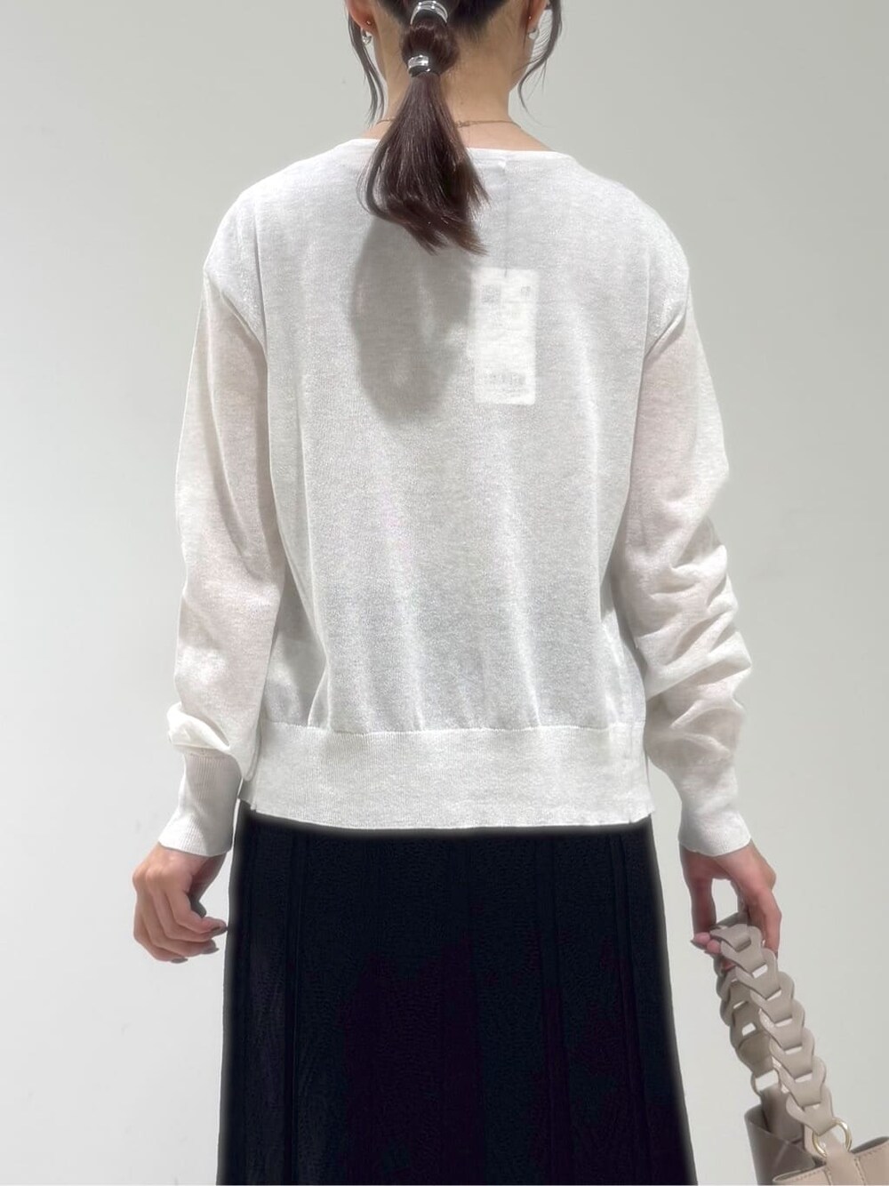 ホワイト系のカーディガン/ボレロ、ブラック系のワンピース、ベージュ系のショルダーバッグを着用したレディースの夏コーディネートの4枚目の写真