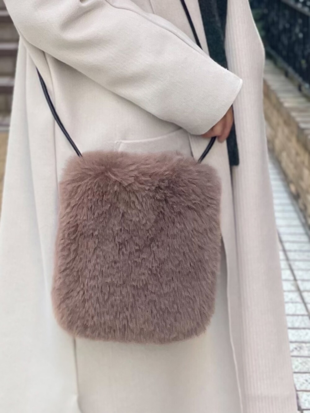 ブラウン系のその他パンツ、グレー系のニット/セーター、ホワイト系のカーディガン/ボレロを着用したレディースの冬コーディネートの5枚目の写真