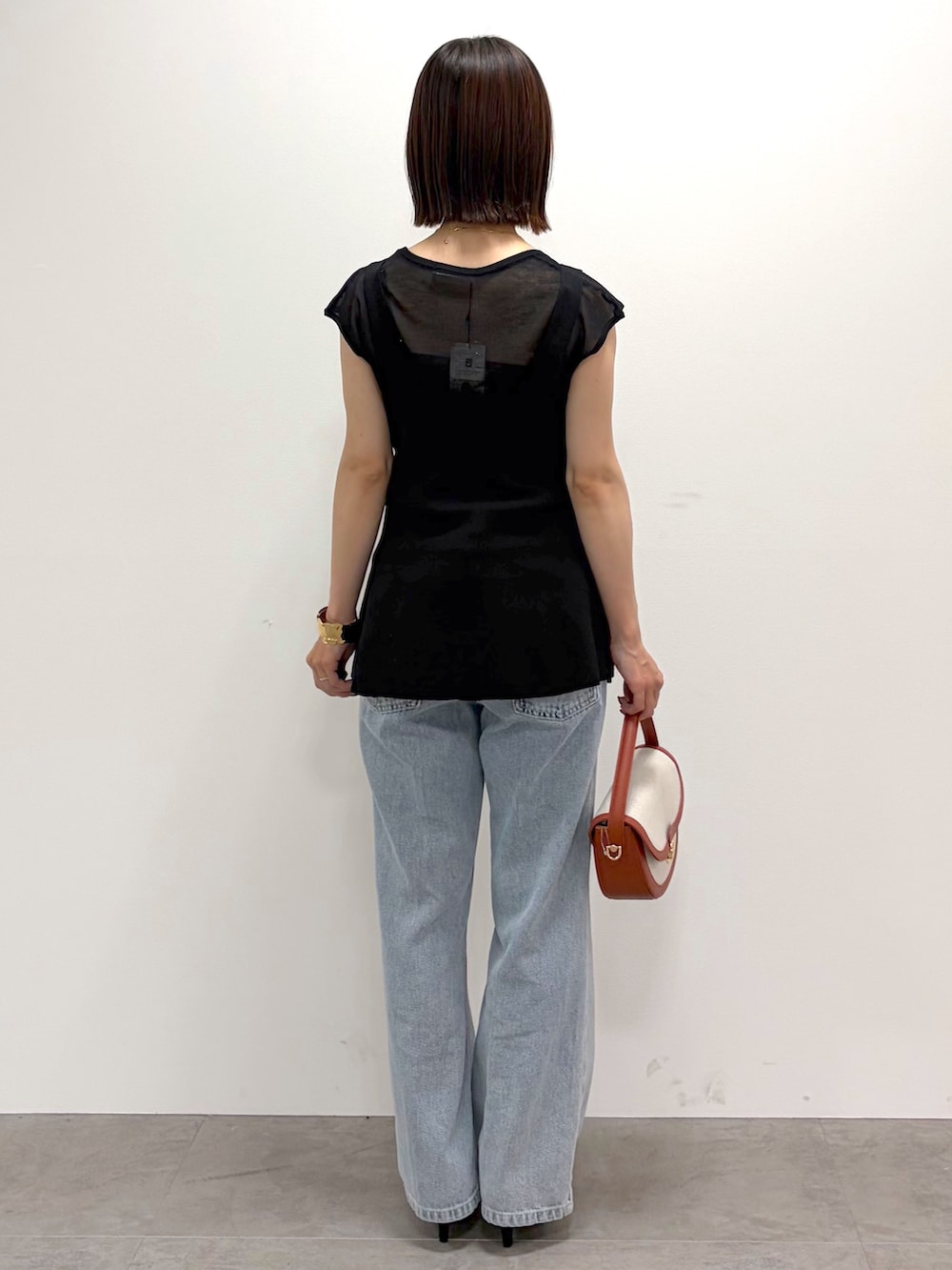 ブラック系のタンクトップ、ブルー系のその他パンツ、レッド系のショルダーバッグを着用したレディースの夏コーディネートの3枚目の写真