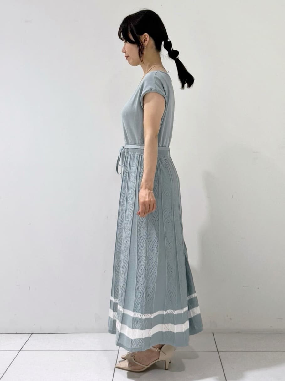 グリーン系のワンピース、ブラック系のハンドバッグ、ベージュ系のパンプスを着用したレディースの夏コーディネートの2枚目の写真
