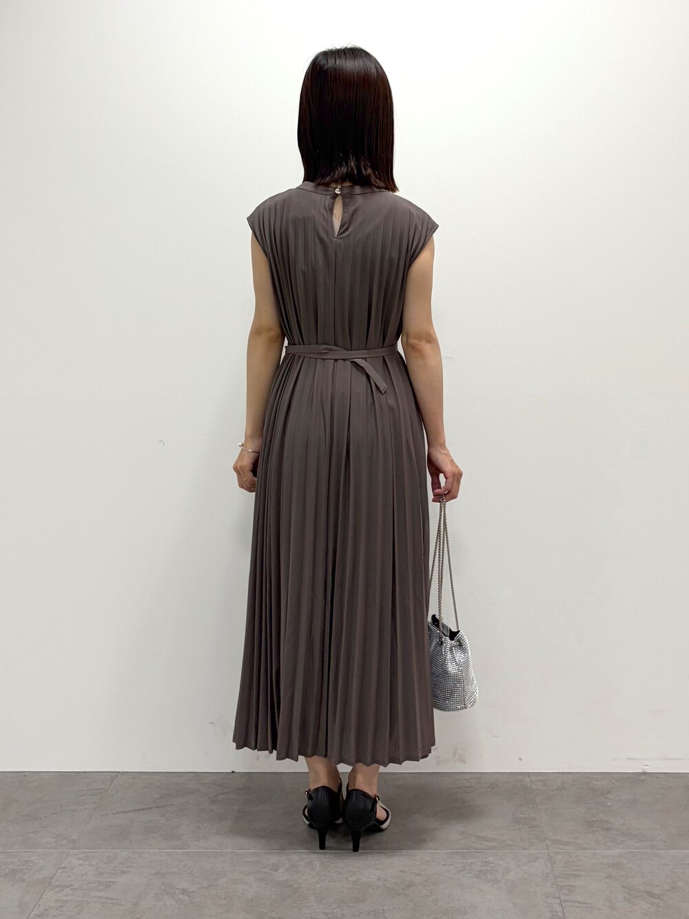 ベージュ系のノーカラージャケット、ブラウン系のワンピース、ホワイト系のショルダーバッグを着用したレディースの春コーディネートの7枚目の写真