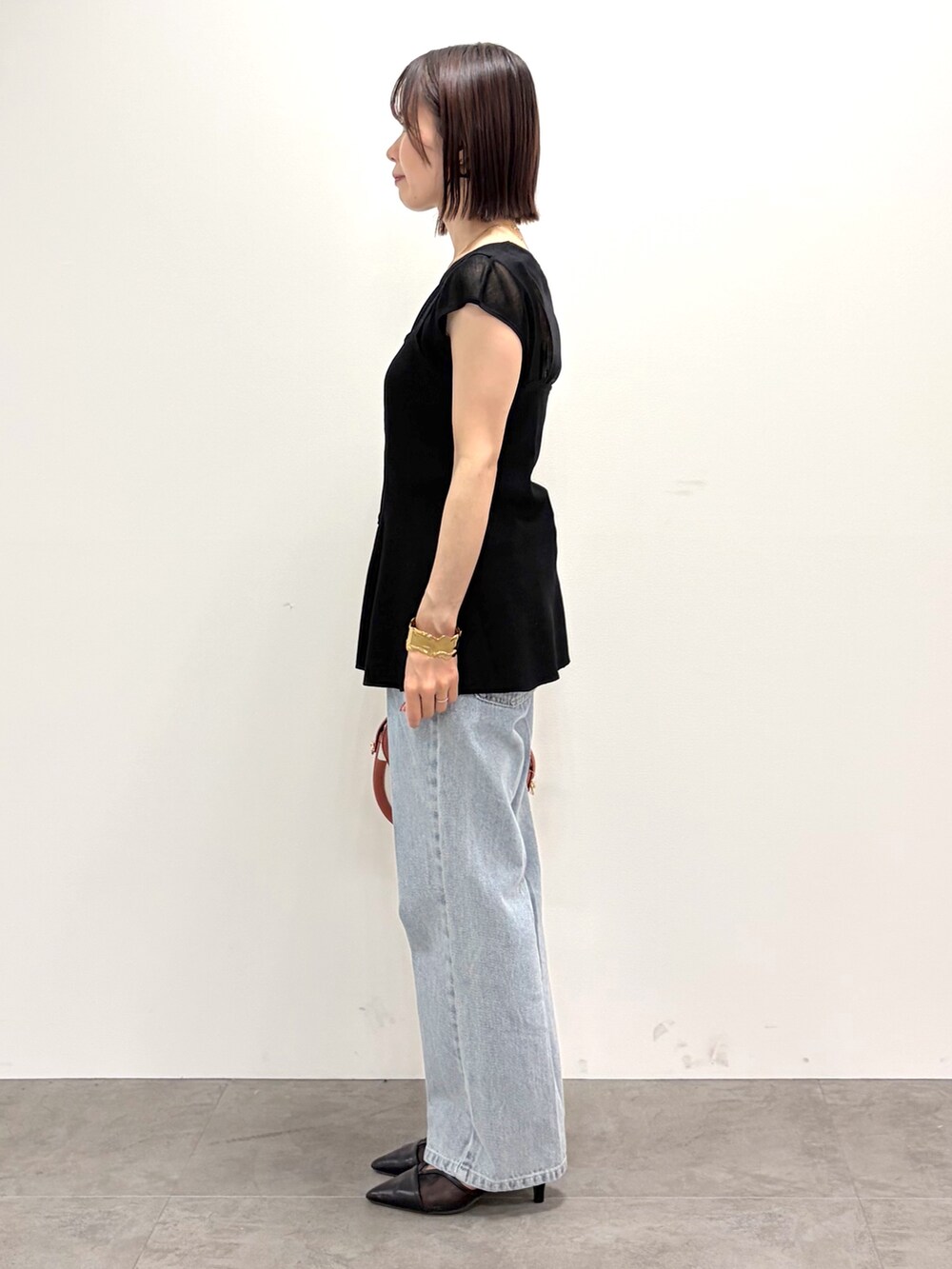 ブラック系のタンクトップ、ブルー系のその他パンツ、レッド系のショルダーバッグを着用したレディースの夏コーディネートの2枚目の写真