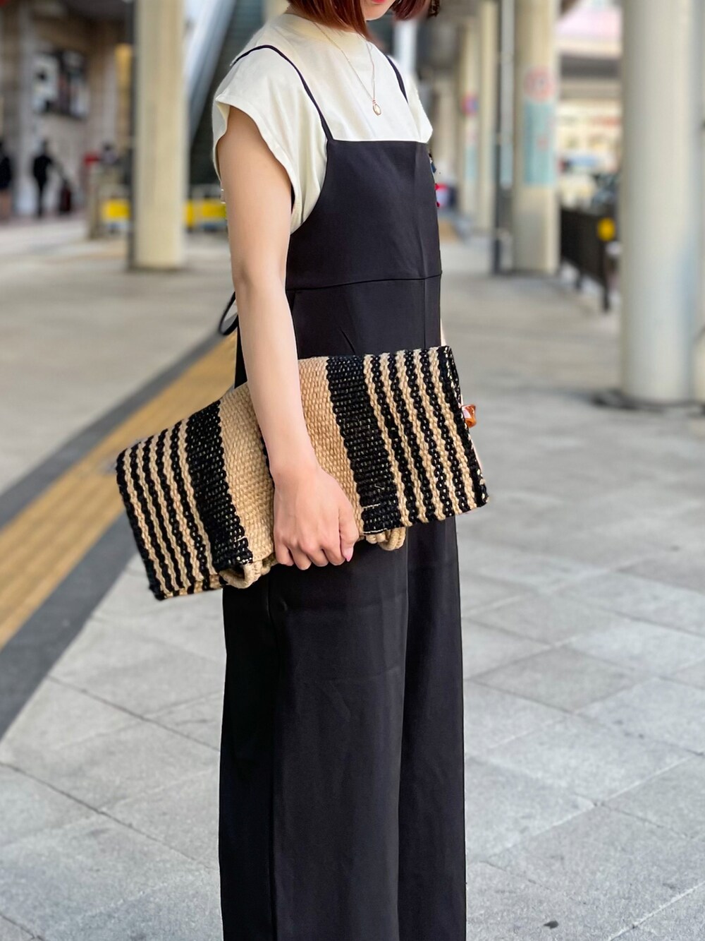 ブラック系のサロペット/オーバーオール、グレー系のTシャツ/カットソー、ベージュ系のサンダルを着用したレディースの春コーディネートの5枚目の写真