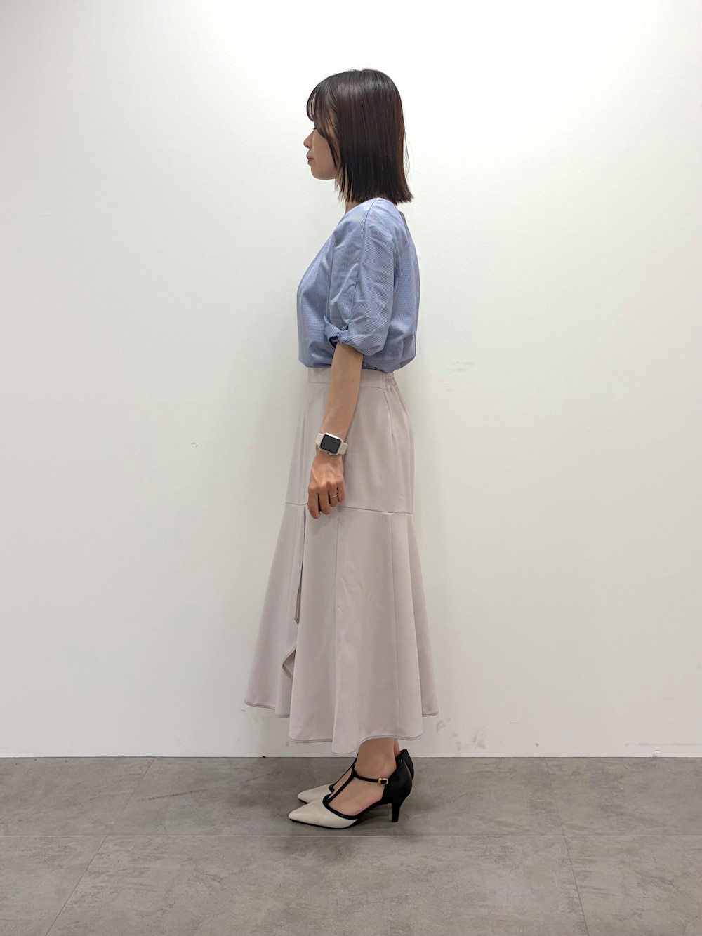 ブルー系のTシャツ/カットソー、ベージュ系のスカート、ホワイト系のトートバッグを着用したレディースの春コーディネートの4枚目の写真
