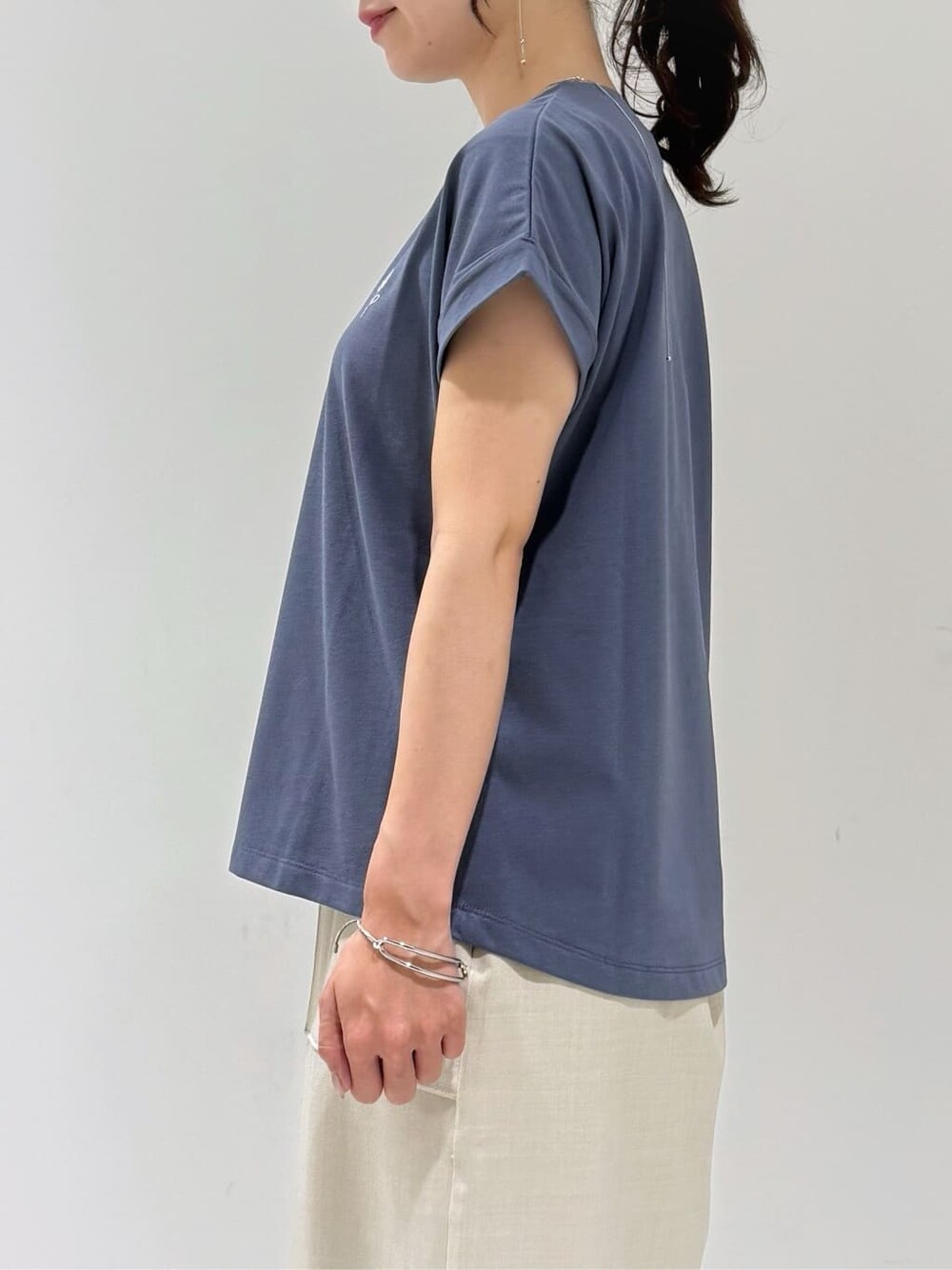 ブラック系のカーディガン/ボレロ、グレー系のTシャツ/カットソー、ベージュ系のスカートを着用したレディースの夏コーディネートの6枚目の写真